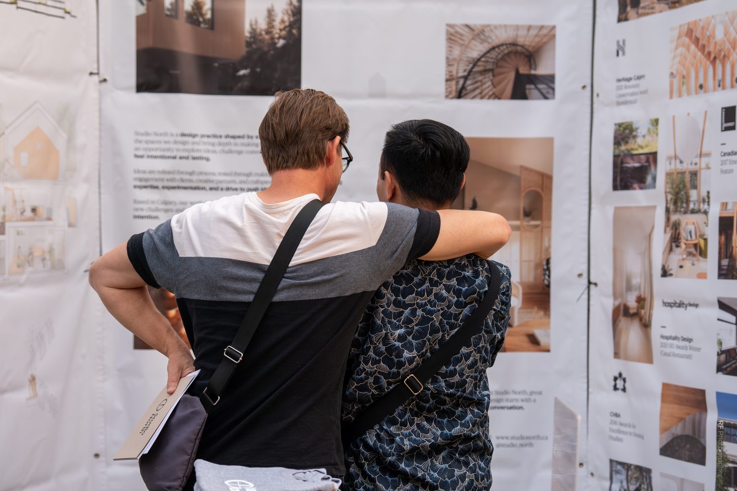 Two visitors looking closely at the project display boards.