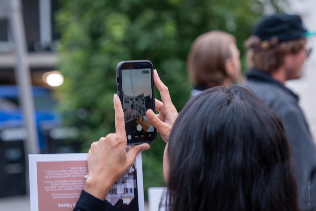 A visitor photographing the display at dusk.