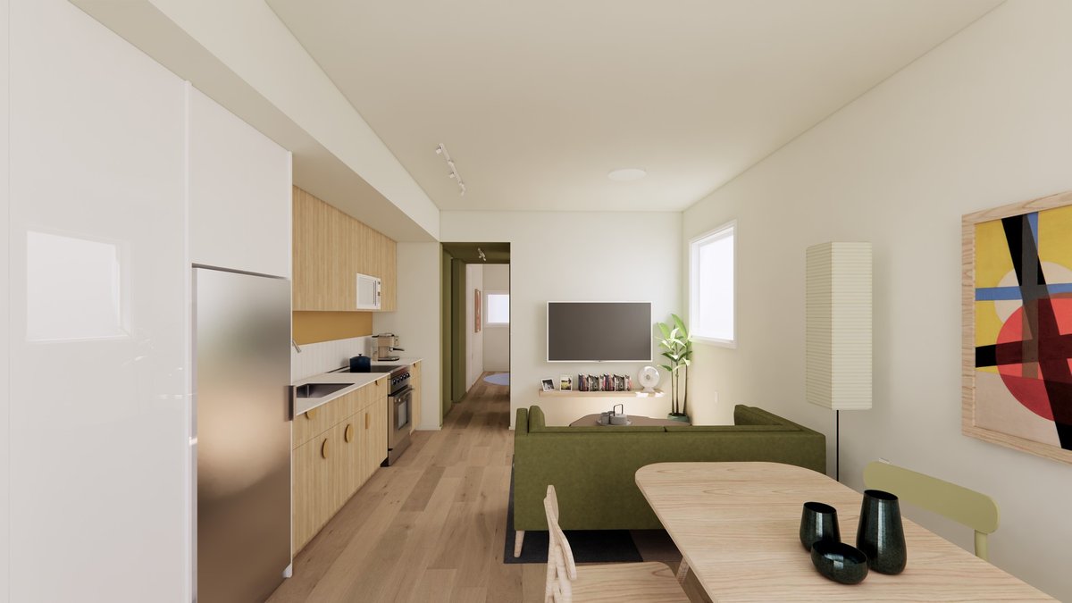 One-bedroom interior with kitchen, sofa, and dining table in natural light.